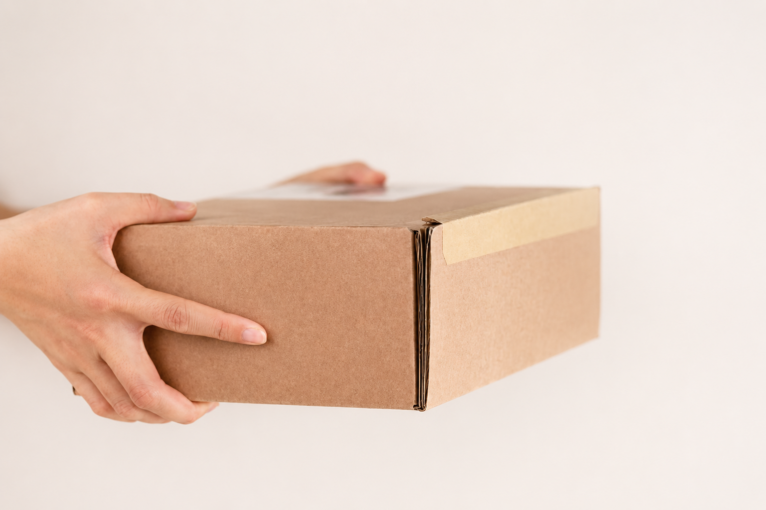 A discreet cardboard package being held for delivery.